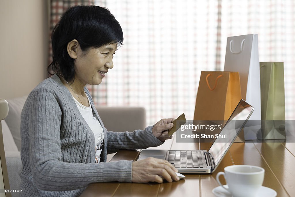 Senior woman shopping online with a credit card