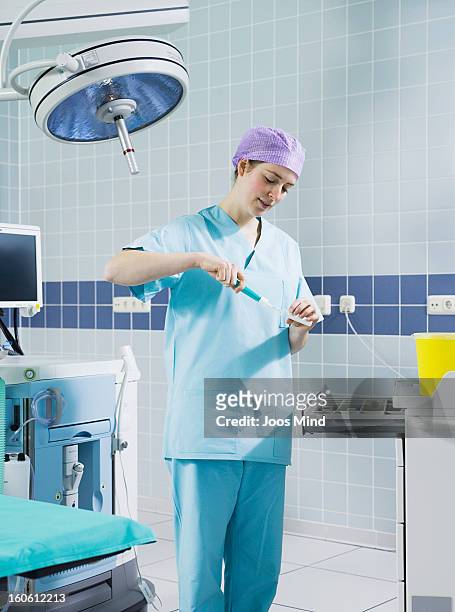 female coctor preparing anaesthetic medicine - anästhesist stock-fotos und bilder
