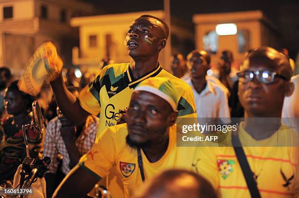 People react as they watch on TV the African Cup of Nation 2013 quarter final football match between Burkina Faso and Togo, in Lome, on February 3,...