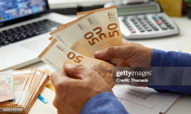 close-up of man's hand holding and counting money, eu banknotes, - eurozone crisis stock pictures, royalty-free photos & images