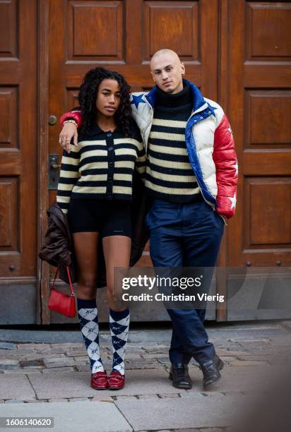 Couple wears striped cardigan outside Baum und Pferdgarten during the Copenhagen Fashion Week Spring/Summer 2024 on August 09, 2023 in Copenhagen,...