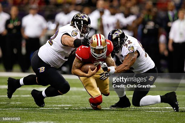Colin Kaepernick of the San Francisco 49ers is tackled by Haloti Ngata and Ray Lewis of the Baltimore Ravens in the first quarter during Super Bowl...