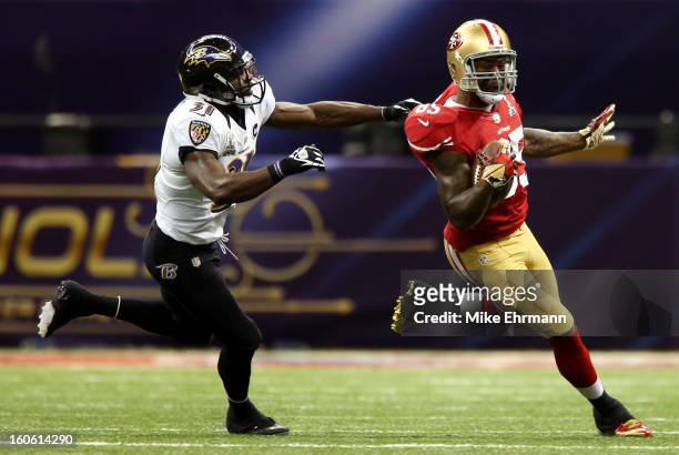 Bernard Pollard of the Baltimore Ravens tries to tackle Vernon Davis of the San Francisco 49ers after a catch in the first half during Super Bowl...