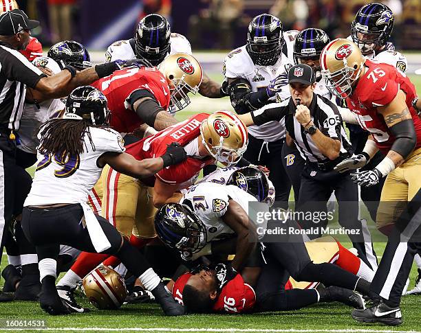 Anthony Davis of the San Francisco 49ers and Bernard Pollard of the Baltimore Ravens get rough with each other at the bottom of a pile in the second...