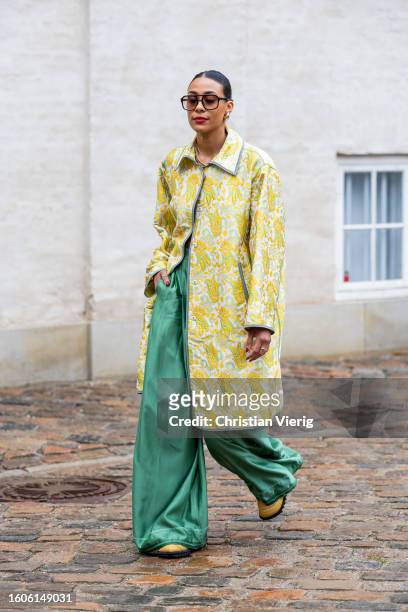 Guest wears yellow jacket, green pants outside Marimekko during the Copenhagen Fashion Week Spring/Summer 2024 on August 09, 2023 in Copenhagen,...