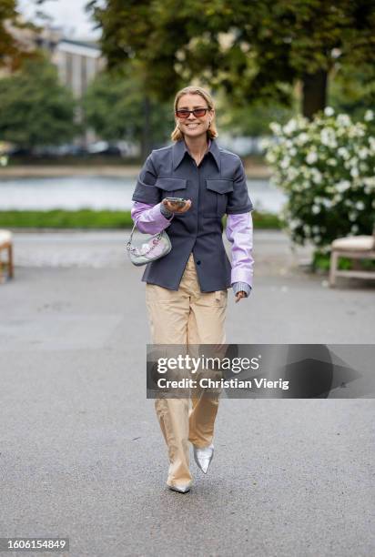 Guest wears grey jacket, beige pants, pink button shirt outside Stine Goya during the Copenhagen Fashion Week Spring/Summer 2024 on August 09, 2023...