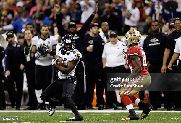 Ed Reed of the Baltimore Ravens runs with the ball against Vernon Davis of the San Francisco 49ers after an interception in the second quarter during...