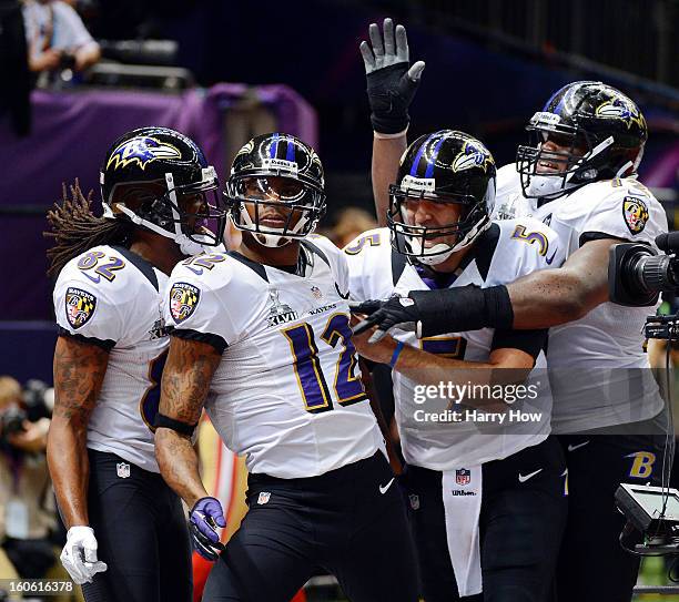 Torrey Smith, Jacoby Jones and Joe Flacco of the Baltimore Ravens celebrate after Jones scored on a 56-yard touchdown pass by Flacco in the second...