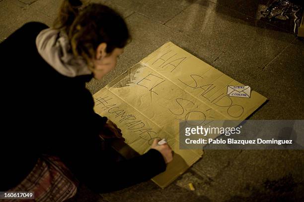 Protestor makes a sign at a protest that reads 'The sun is out. Acampadasol' in Puerta del Sol Square after a demonstration against alleged...