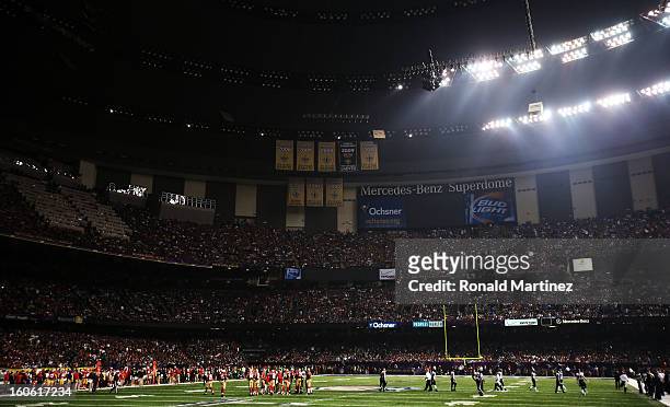 Players from the Baltimore Ravens and the San Francisco 49ers stand on the field as play was suspended due to a 34 minute power outage in the third...