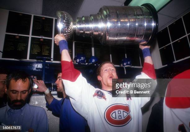 Mike Keane of the Montreal Canadiens holds the Stanley Cup in the locker room after the Canadiens defeated the Los Angeles Kings in Game 5 of the...