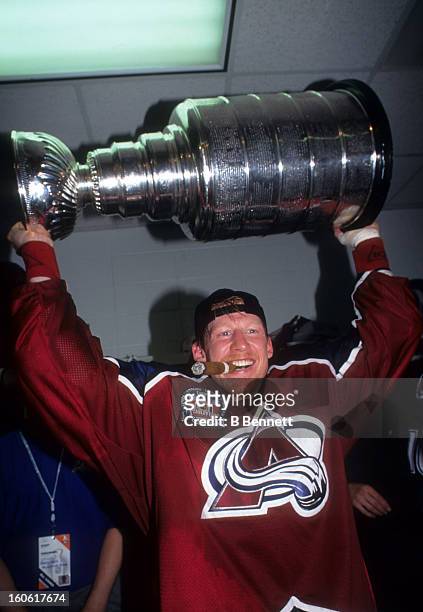 Mike Keane of the Colorado Avalanche holds the Stanley Cup in the locker room after the Avalanche defeated the Florida Panthers in Game 4 of the 1996...