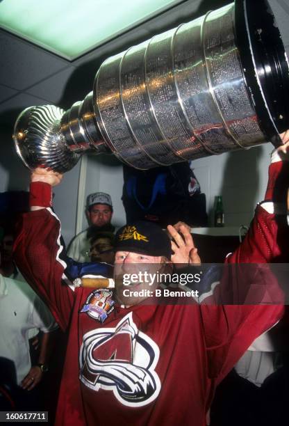 Mike Keane of the Colorado Avalanche holds the Stanley Cup in the locker room after the Avalanche defeated the Florida Panthers in Game 4 of the 1996...