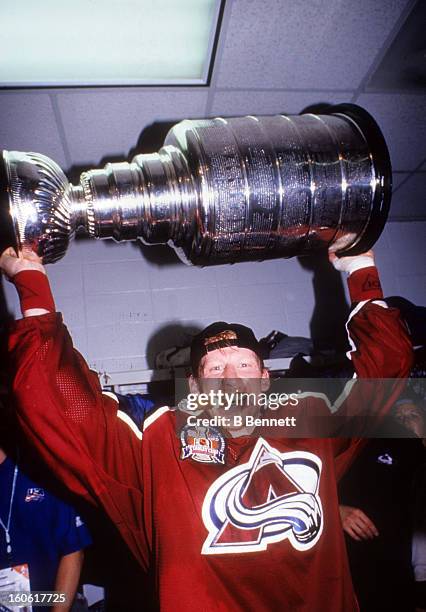 Mike Keane of the Colorado Avalanche holds the Stanley Cup in the locker room after the Avalanche defeated the Florida Panthers in Game 4 of the 1996...