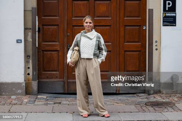Hollie Mercedes Peters wears bomber jacket, beige pants, Bottega Veneta bag outside Baum & Pferdgarten during the Copenhagen Fashion Week...