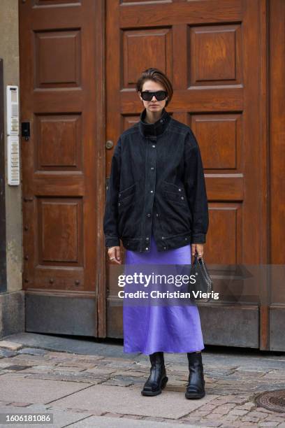 Jacqueline Zelwis wears denim jacket, purple silk skirt outside Baum & Pferdgarten during the Copenhagen Fashion Week Spring/Summer 2024 on August...