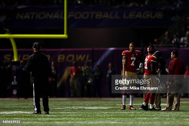 Colin Kaepernick, Frank Gore, and head coach Jim Harbaugh of the San Francisco 49ers wait on the field during a power outage that occured in the...