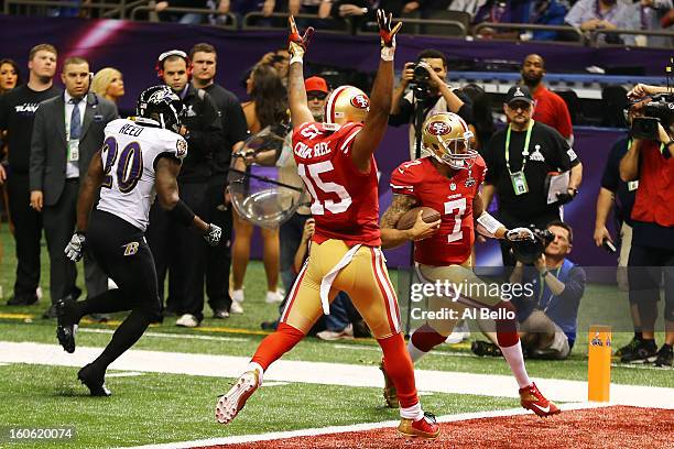 Colin Kaepernick of the San Francisco 49ers runs in for a touchdown in the fourth quarter in front of teammate Michael Crabtree past Ed Reed of the...