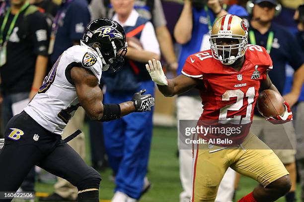 Frank Gore of the San Francisco 49ers runs with the ball before stiff-arming Ed Reed of the Baltimore Ravens during Super Bowl XLVII at the...