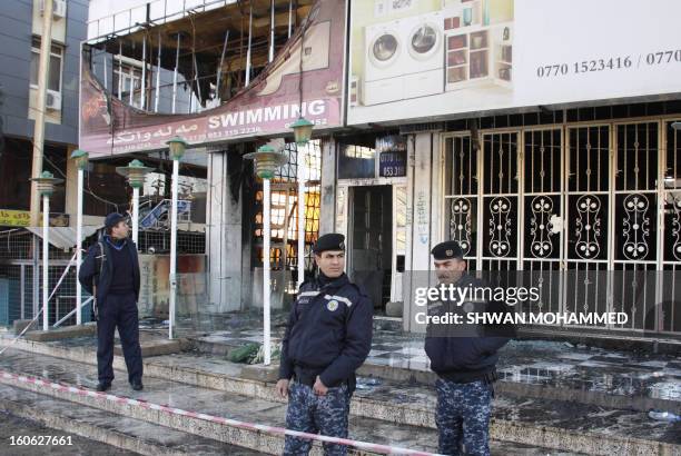 Iraq police stand in front of a burnt out building affiliated to the University of Sulaimaniyah, in the northern mainly Kurdish region of Iraq, on...