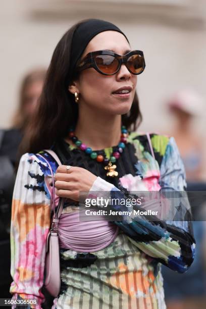 Nicole Huisman seen outside Marimekko show wearing brown Ganni sunnies, gold hoop earrings, colorful pearl necklace, small rose colored Prada Cleo...