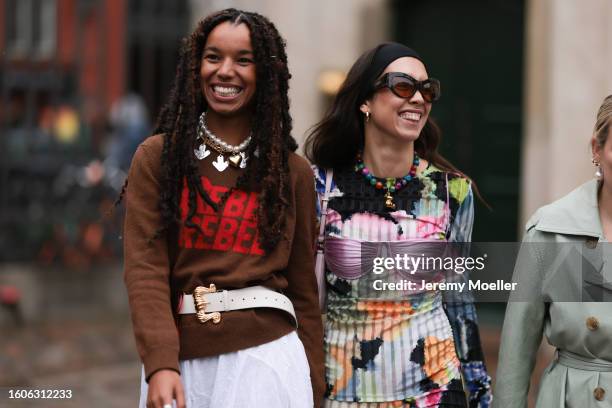 Nicole Huisman seen wearing brown Ganni sunnies, gold hoop earrings, colorful pearl necklace, small rose colored Prada Cleo handbag, colorful printed...