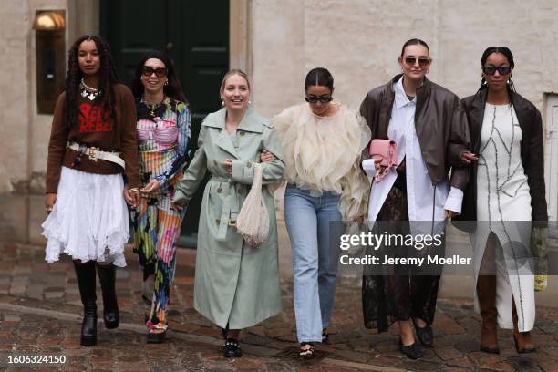 Nicole Huisman seen wearing brown Ganni sunnies, gold hoop earrings, colorful pearl necklace, small rose colored Prada Cleo handbag, colorful printed...