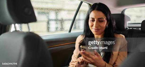 heading to her next meeting by taxi - crowdsourced taxi stock pictures, royalty-free photos & images