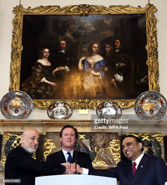 Britain's Prime Minister David Cameron shakes hands with Afghan President Hamid Karzai and Pakistani President Asif Ali Zardari at the Prime...