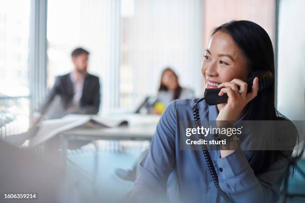 office team member on the phone - telefone fixo imagens e fotografias de stock