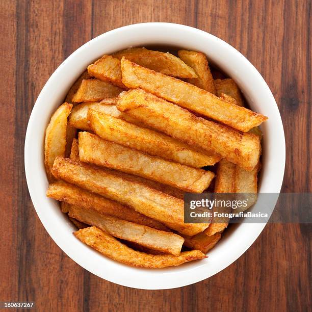 thick-cut potato fries in a bowl on wood grain - patatas bravas bildbanksfoton och bilder