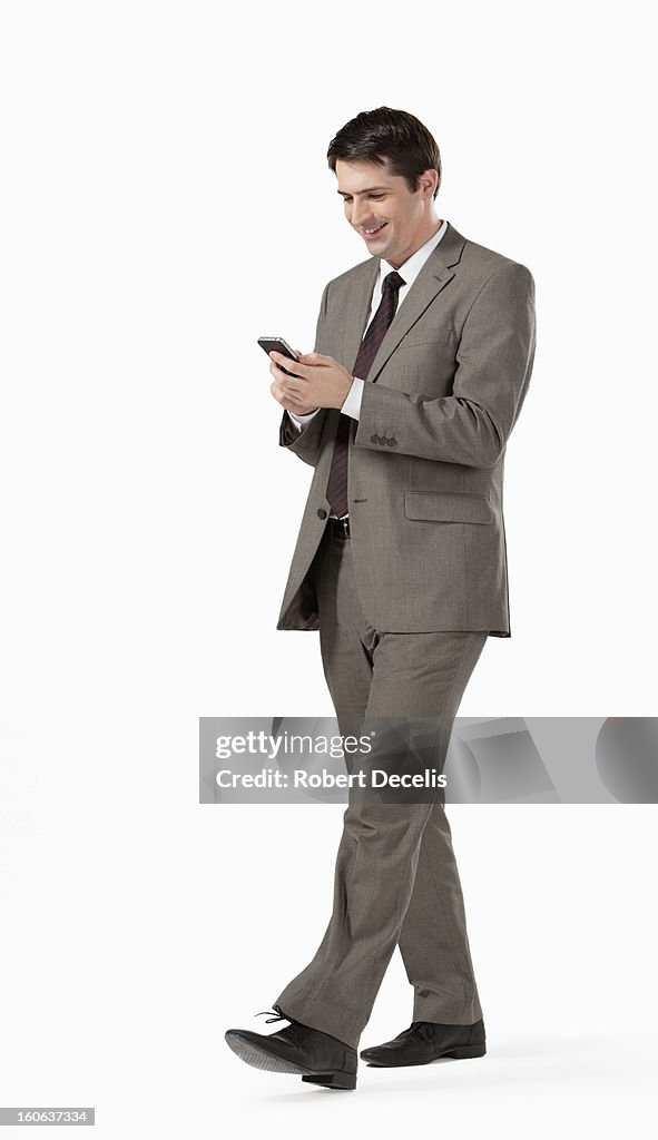 Man walking along looking at smart phone