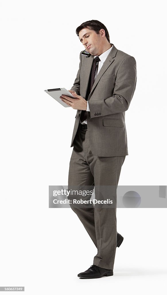 Business man using tablet whilst using smart phone