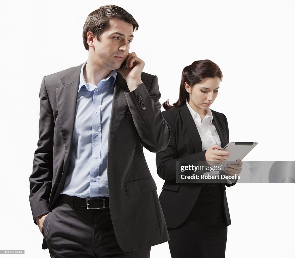 Business man using smart phone colleague behind
