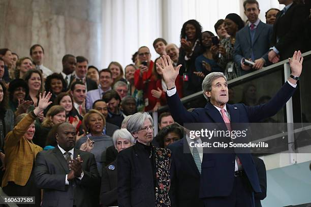 Secretary of State John Kerry waves to employees in the C Street Lobby during his first day at the State Department February 4, 2013 in Washington,...