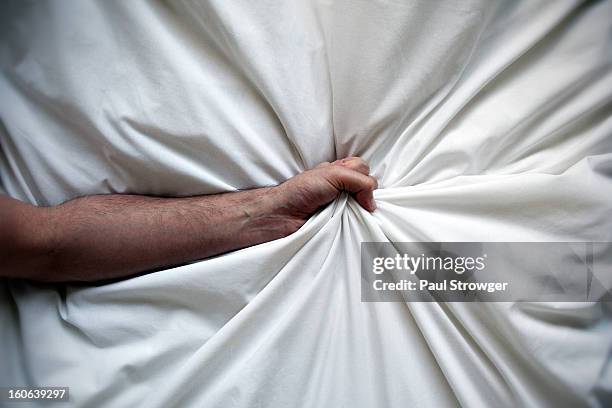 forearm grabbing bedsheet. - hand clutching sheet stock pictures, royalty-free photos & images