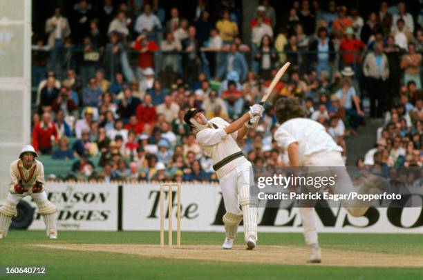 Rick McCosker batting with a broken jaw hits Bob Willis to the boundary. Alan Knott is the wicket-keeper. Centenary Test Australia v England at...