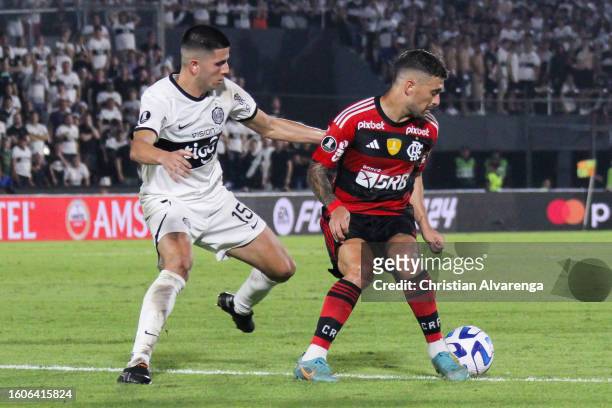 Giorgian De Arrascaeta of Flamengo challenges for the ball with Mateo Gamarra of Olimpia during a Copa CONMEBOL Libertadores 2023 round of sixteen...