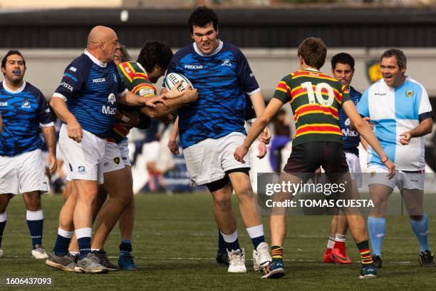 Pumpas XV's Tomas Capani runs trough a tackle of Lomas Athletic Club's players next to teammates Nicolas Agustin Medina Alberto Sanabria Carlos Cejas...