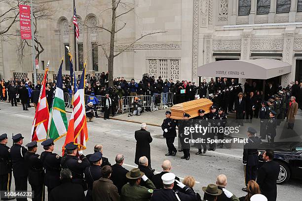 People watch as the casket of former New York City Mayor Ed Koch is brought out by members of the New York Police Department following funeral...