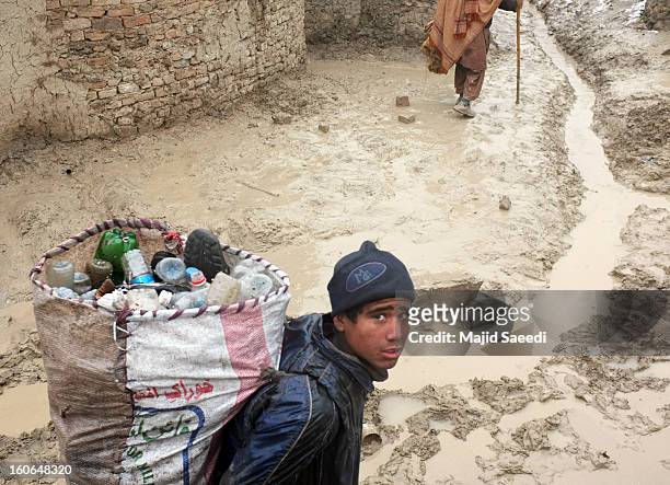An internally displaced Afghan child carries a sack of waste for recycling at Chamand babrak Camp, on February 3, 2013 in Kabul, Afghanistan....
