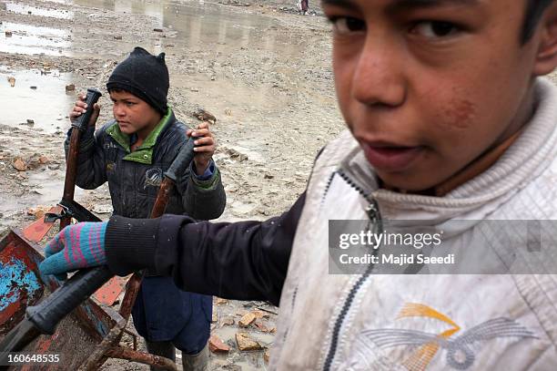 Internally displaced Afghans wait to receive aid donations from the Danish Refugee Council at Chamand babrak Camp, on February 3, 2013 in Kabul,...