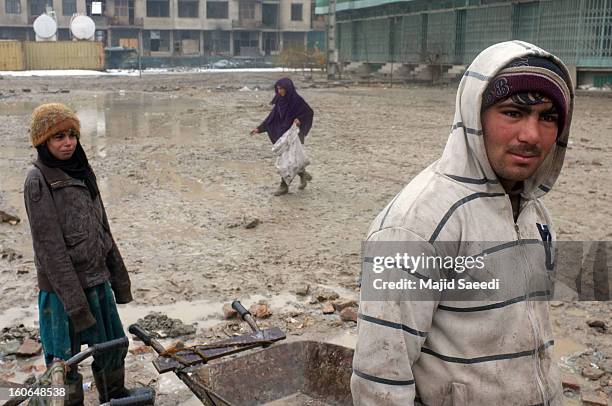 Internally displaced Afghans wait to receive aid donations from the Danish Refugee Council at Chamand babrak Camp, on February 3, 2013 in Kabul,...