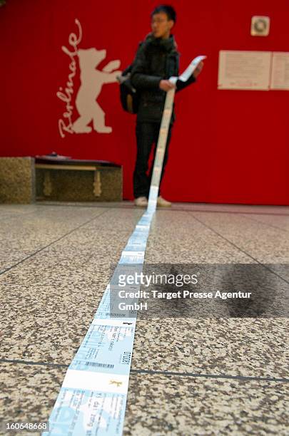 An enthusiast checks behind the ticket office his freshly bought cinema tickets for the 63rd Berlinale International Film Festival on February 4,...