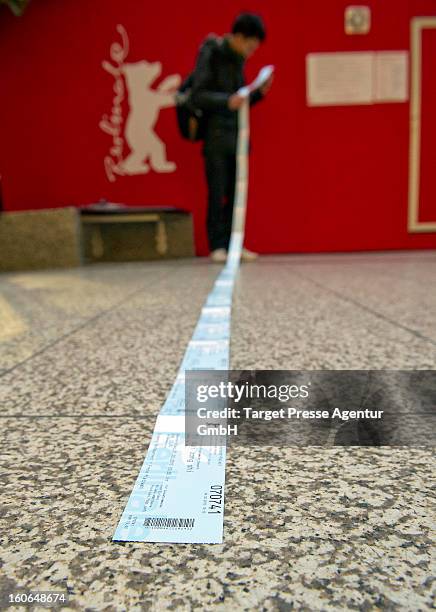 An enthusiast checks behind the ticket office his freshly bought cinema tickets for the 63rd Berlinale International Film Festival on February 4,...