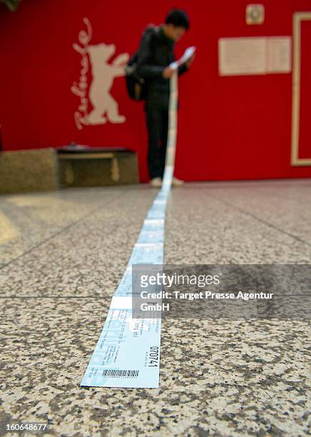 An enthusiast checks behind the ticket office his freshly bought cinema tickets for the 63rd Berlinale International Film Festival on February 4,...