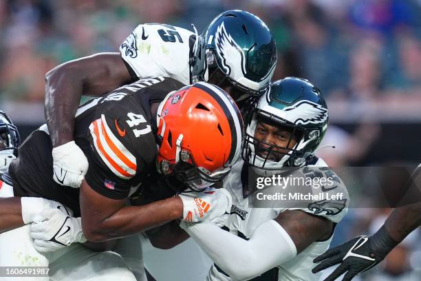 Tarron Jackson and Zach Cunningham of the Philadelphia Eagles tackle John Kelly Jr. #41 of the Cleveland Browns in the first half of the preseason...
