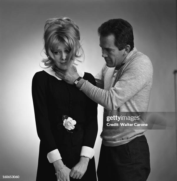 Photo Studio Of Catherine Deneuve. Photo studio : Walter CARONE faisant sembler d'étrangler Catherine DENEUVE vêtue d'une petite robe noire à col...