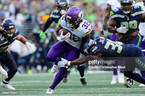 Running back Ty Chandler of the Minnesota Vikings is tackled by cornerback Michael Jackson of the Seattle Seahawks during the first quarter against...
