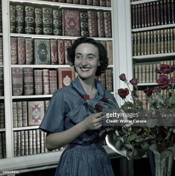 Rendezvous With Princess Napoleon. France- 1949- La princesse NAPOLEON épouse du prince Louis Napoléon, pose dans une bibliothèque, souriante.